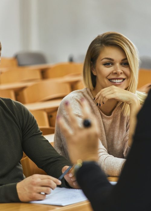 Smiling students and lecturer in auditorium at university